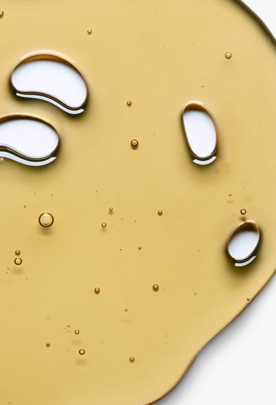 Close up of yellow liquid with air bubbles on white background