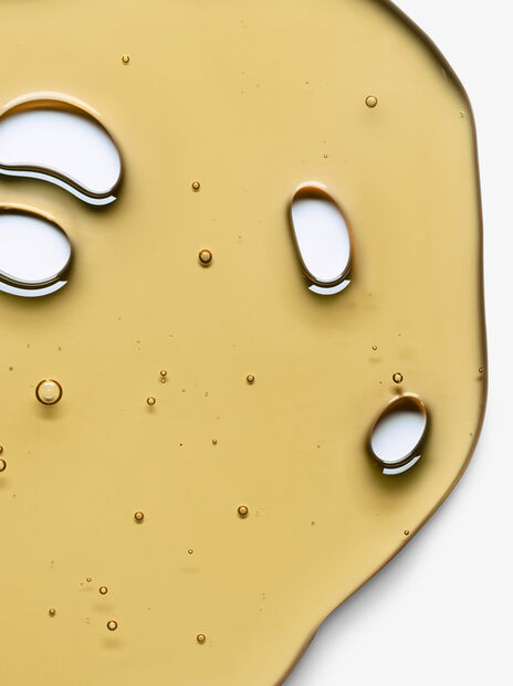 Close up of yellow liquid with air bubbles on white background