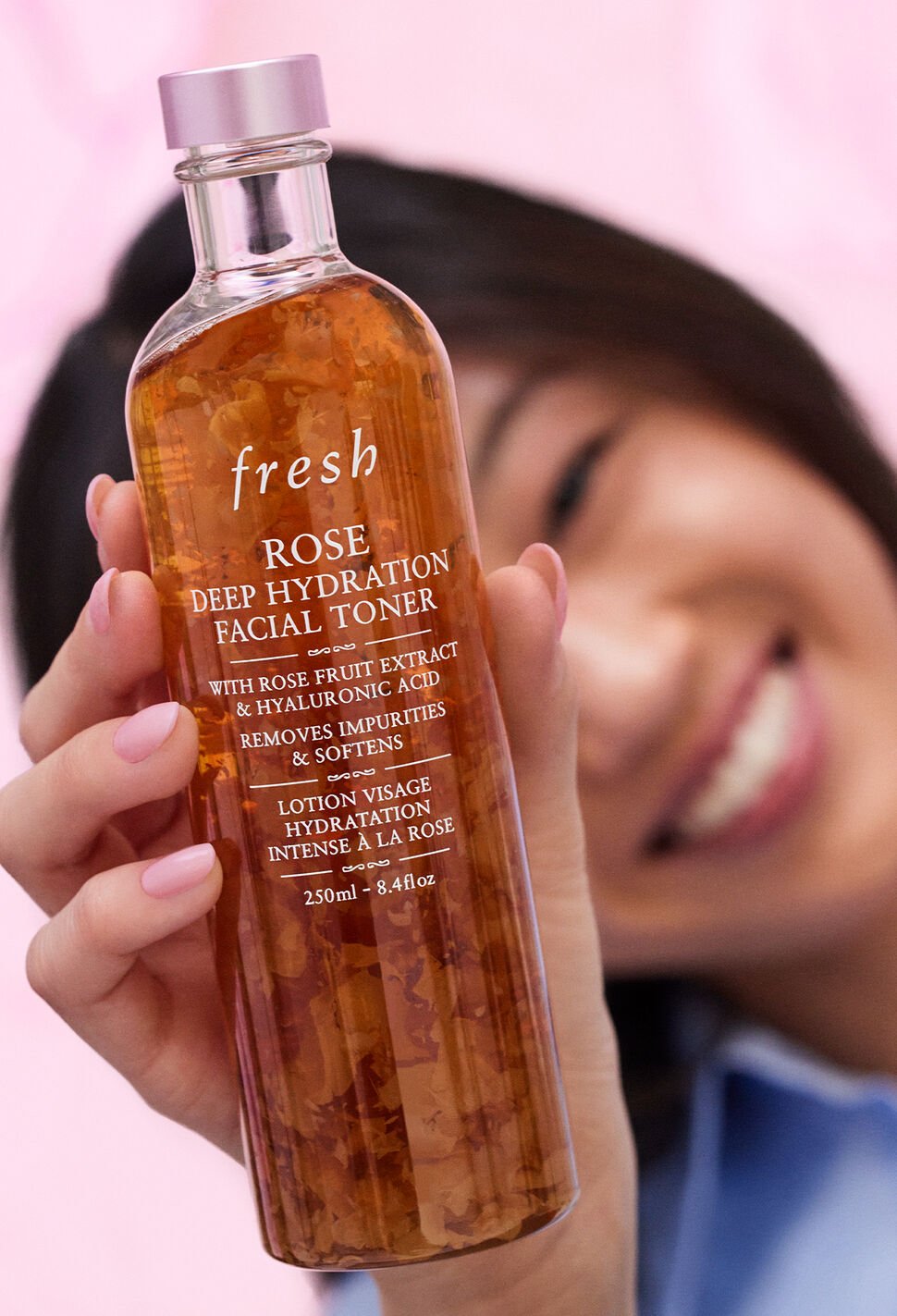 Close up of a smiling woman holding Rose Toner