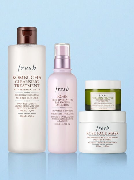 Fresh Kombucha Cleanser, Rose Face Mist, Rose Face Mask and Vitamin Nectar on blue background